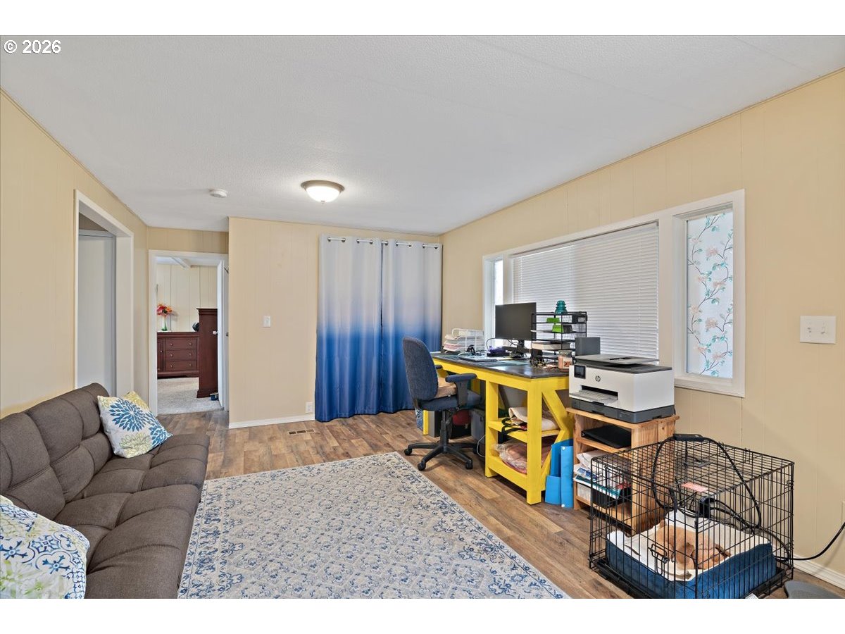 5355 River Road North, Unit 60 Keizer, OR 97303 - Photo 17 of 29 a living room with furniture a desk and chair with potted plants