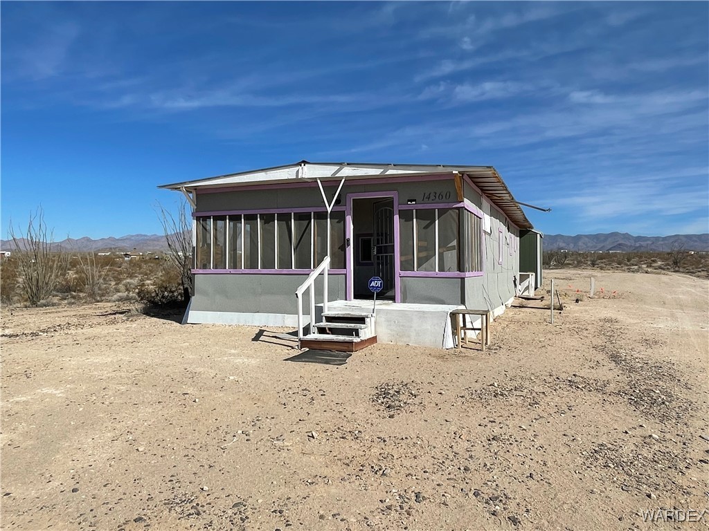 14360 Aripine Road Yucca, AZ 86438 - Photo 1 of 33 a view of a house with backyard porch and garden