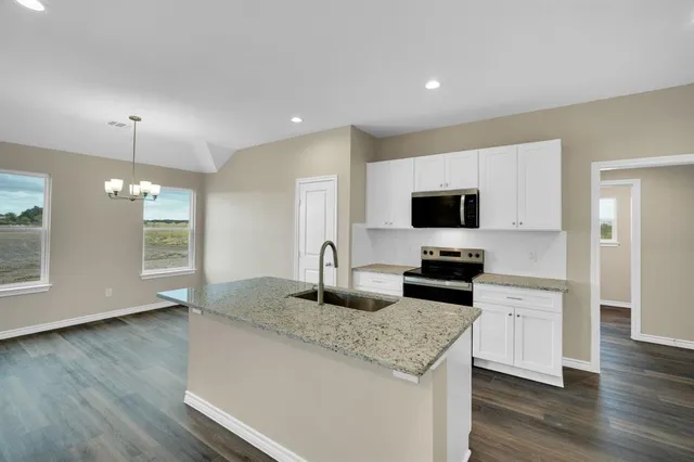 a kitchen with stainless steel appliances granite countertop a stove a sink and a microwave