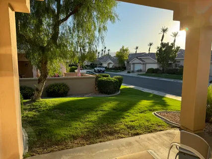a view of a swimming pool with a lawn chairs under an umbrella