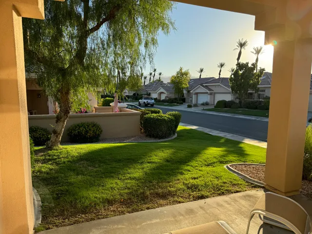 a view of a swimming pool with a lawn chairs under an umbrella