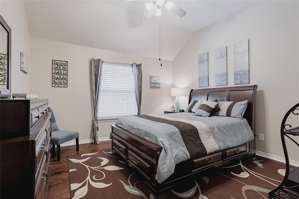 2314 Ranch Road Sachse, TX 75048 - Photo 23 of 27 Vaulted ceiling bedroom featuring wood-finish flooring, a window with horizontal blinds and draperies, and a ceiling fan with light fixture
