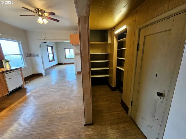 a view of a hallway with wooden floor and staircase