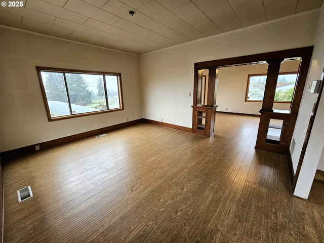 wooden floor in an empty room with a window