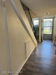 a view of hallway with stairs and wooden floor