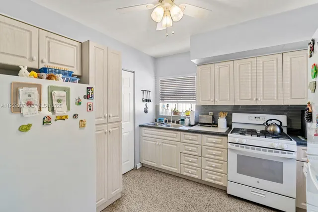 a kitchen with stainless steel appliances a white cabinets and a refrigerator