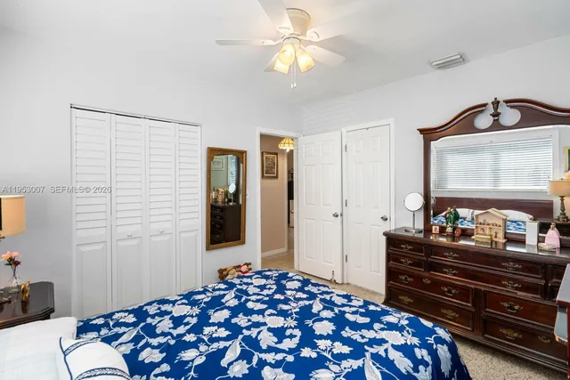 a bedroom with a bed and a dresser with mirror