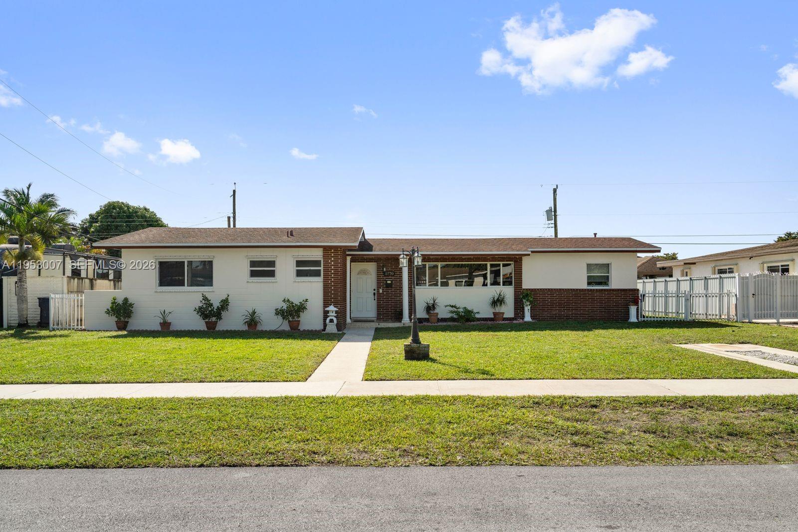 5770 Northwest 111th Street Hialeah, FL 33012 - Photo 3 of 32 a front view of a house with swimming pool having outdoor seating