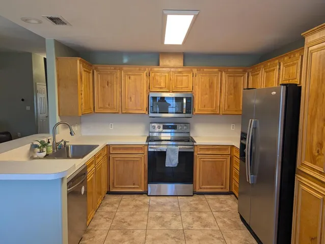 a kitchen with stainless steel appliances granite countertop a refrigerator sink and microwave