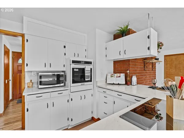 a kitchen with white cabinets and refrigerator