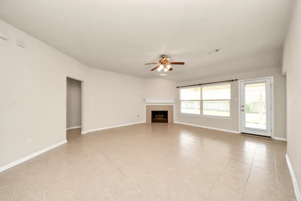 a view of an empty room with a fireplace and window