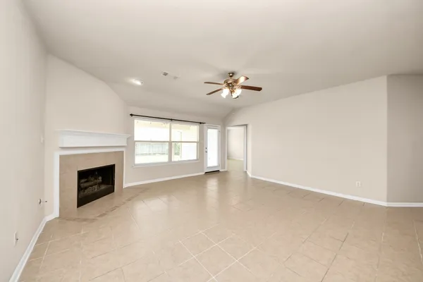 a view of an empty room with a ceiling fan and a window