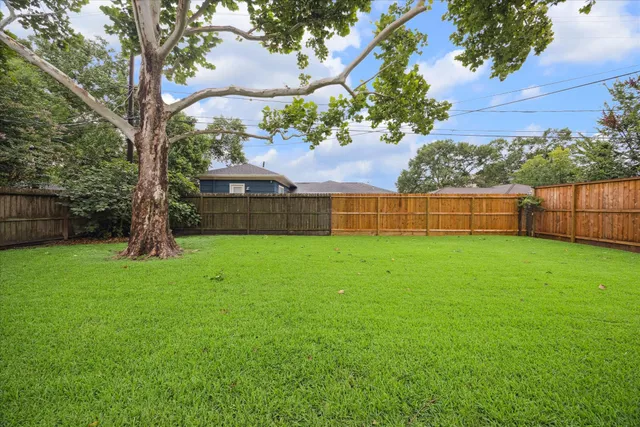 a view of yard with green space and fountain in the back