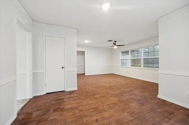 a view of empty room with wooden floor and windows