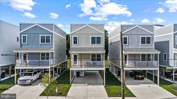 a view of house with a small yard and sitting area