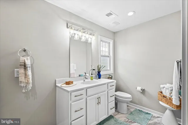 a bathroom with a double vanity sink mirror and toilet