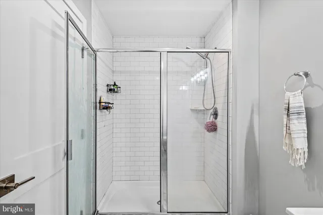 a bathroom with a glass shower door and mirror