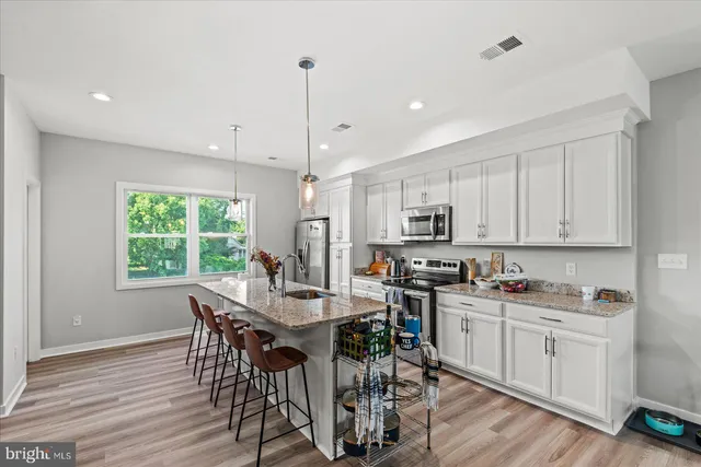 a view of kitchen with sink table and chairs