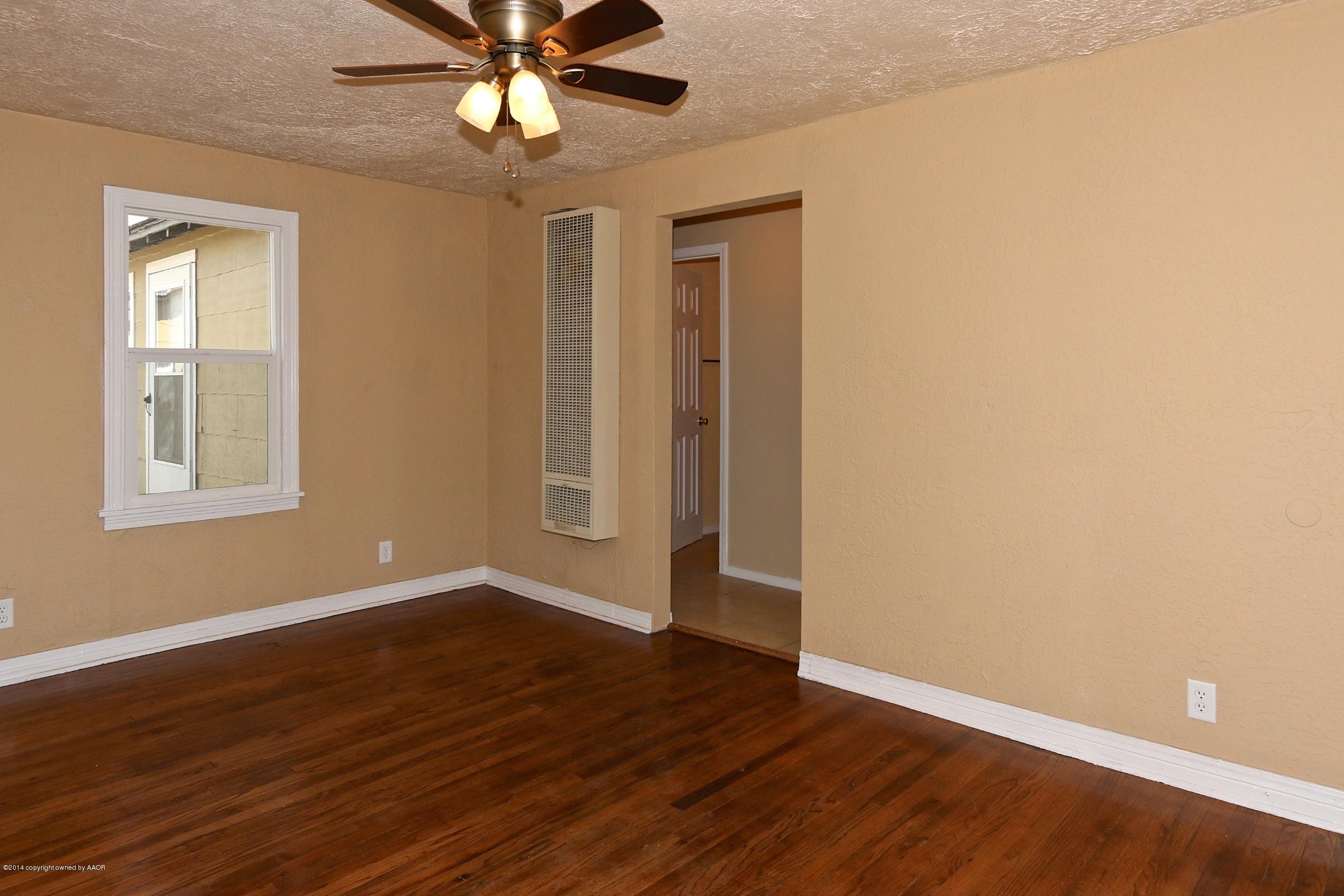 4205 South Tyler Street Amarillo, TX 79110 - Photo 8 of 19 a view of an empty room with window and wooden floor
