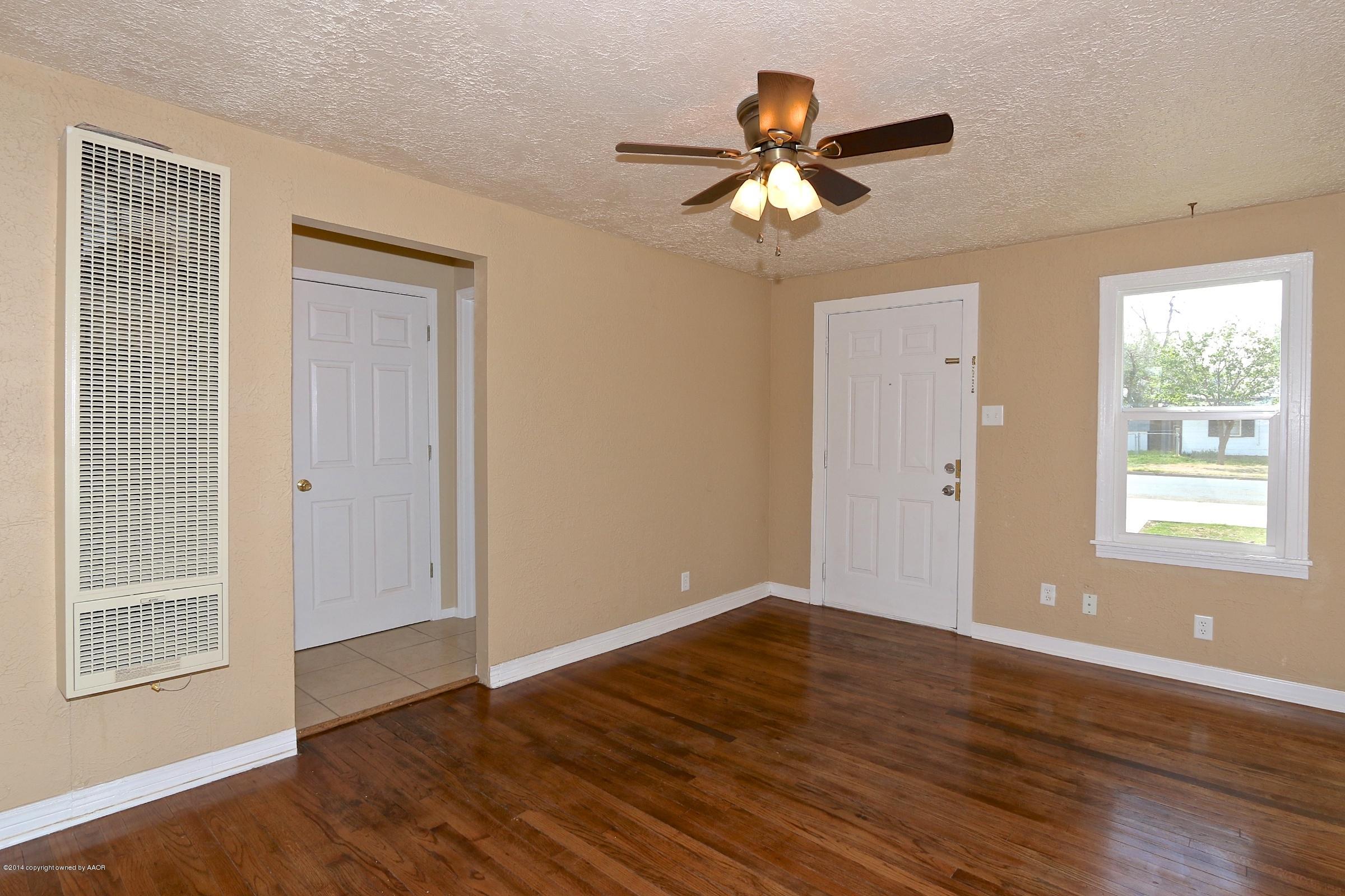 4205 South Tyler Street Amarillo, TX 79110 - Photo 9 of 19 a view of an empty room with wooden floor and a window