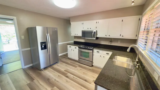 a kitchen with stainless steel appliances a refrigerator sink and microwave
