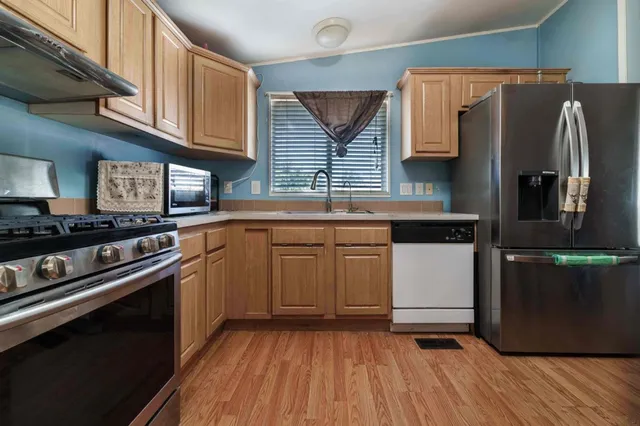 a kitchen with granite countertop white cabinets and stainless steel appliances