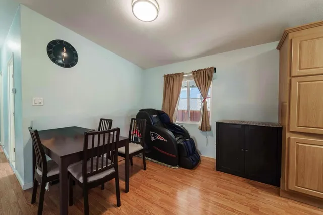 a view of a hallway with wooden floor and a bathroom