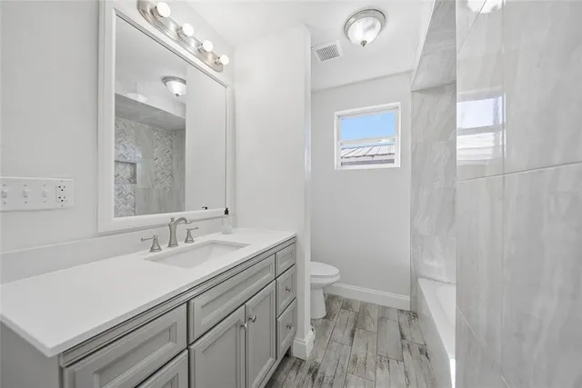 a bathroom with a sink a toilet and a mirror