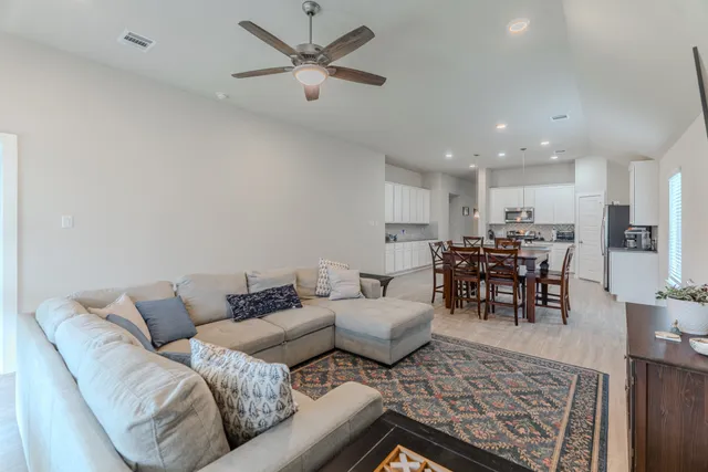 a living room with furniture and kitchen view