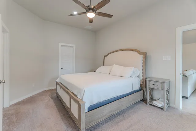 a bedroom with a bed and a ceiling fan