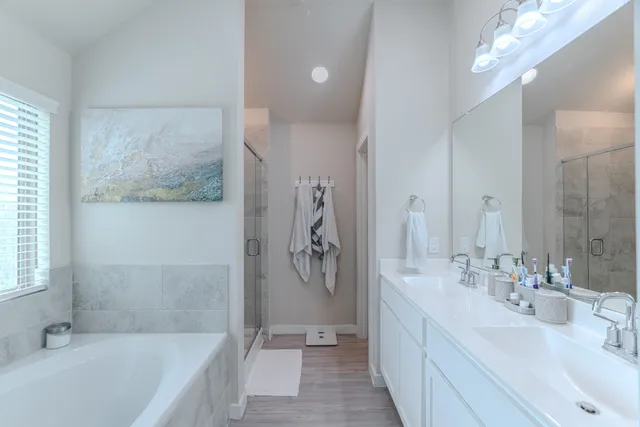 a spacious bathroom with a tub sink and mirror