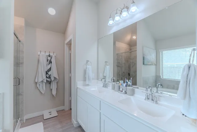 a bathroom with a double vanity sink and shower