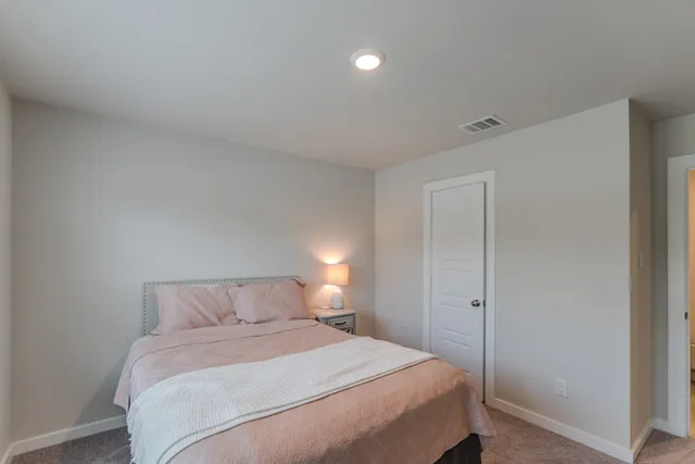 a bedroom with a bed and a night stand