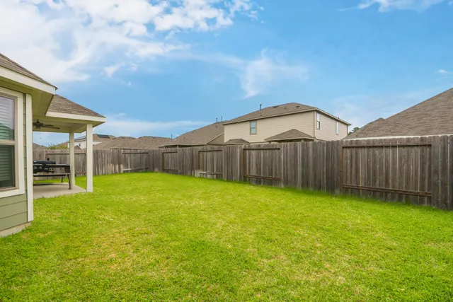 a view of a backyard with wooden fence
