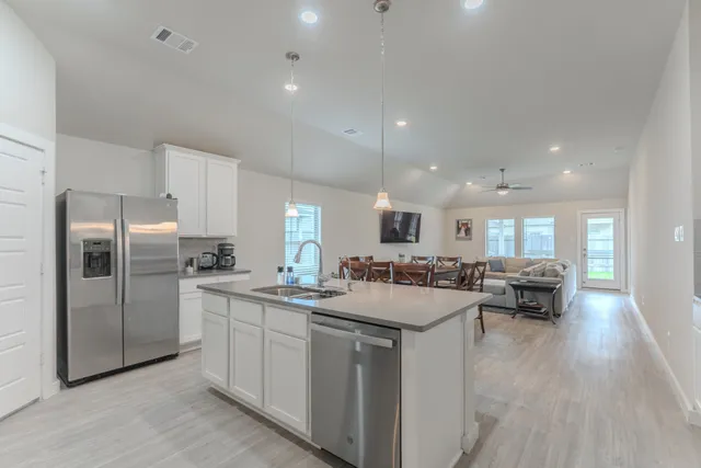 a kitchen with refrigerator a sink and chairs