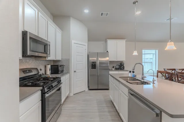 a kitchen with refrigerator a stove top oven a sink and dishwasher