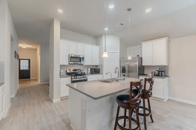 a kitchen with a sink a counter top space stainless steel appliances and cabinets