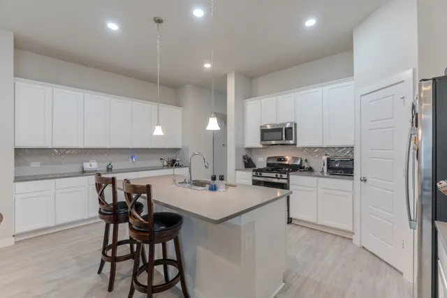 a kitchen with white cabinets and stainless steel appliances