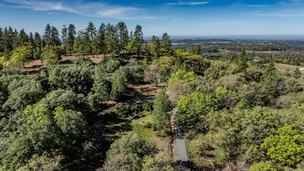 an aerial view of a house with a yard and lake view