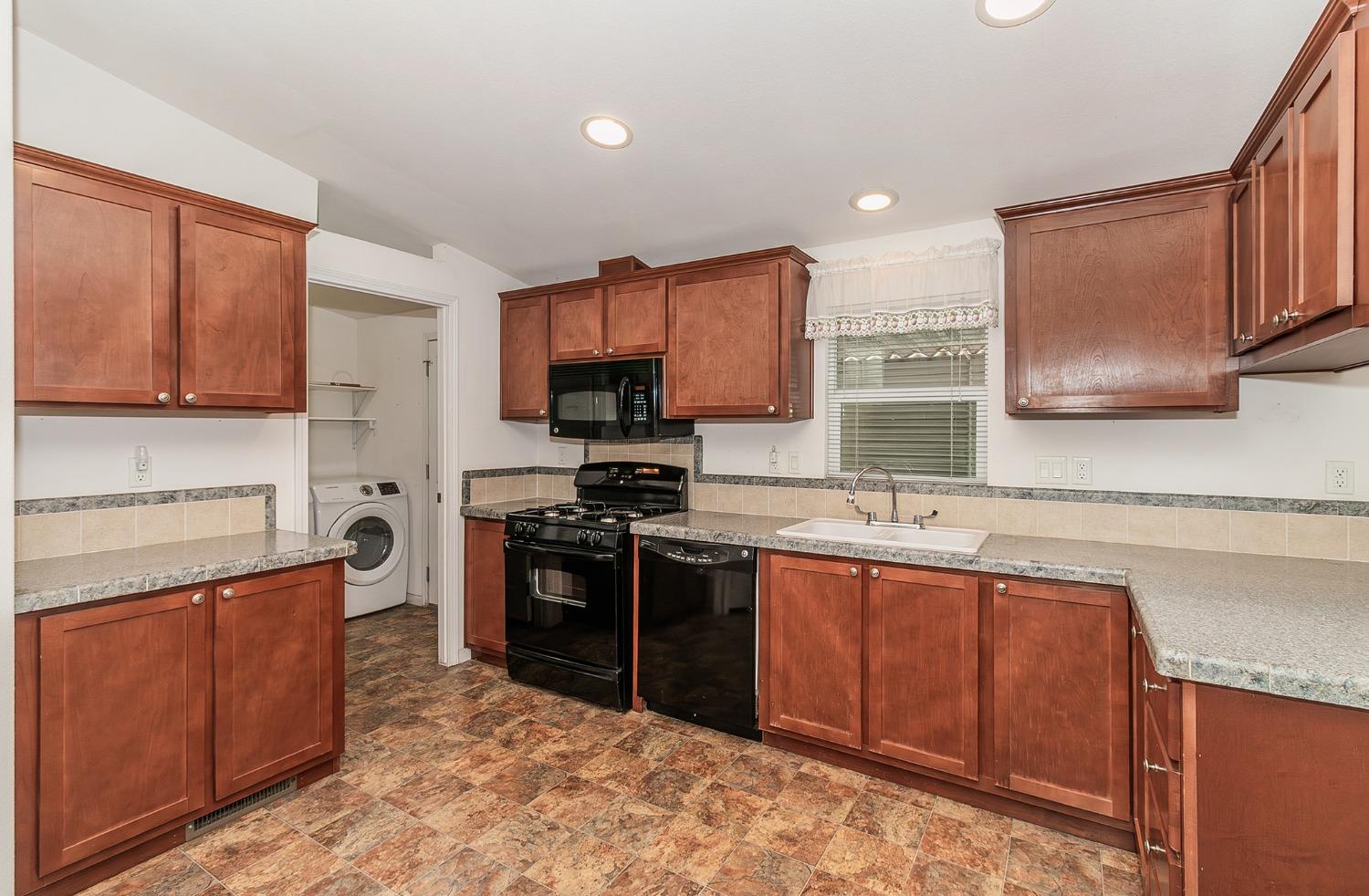 a kitchen with stainless steel appliances granite countertop a stove top oven a sink dishwasher and a microwave oven on the blue kitchen countertops