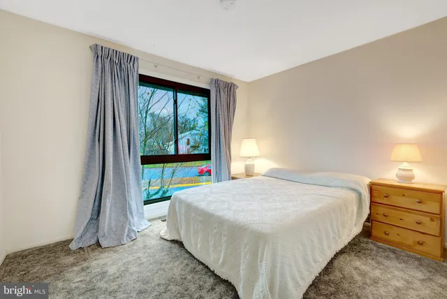 a bed sitting in a bedroom next to a window