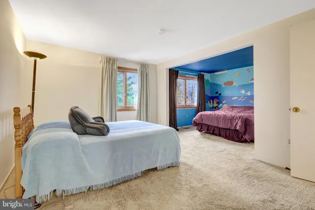 a bedroom with two beds and a window