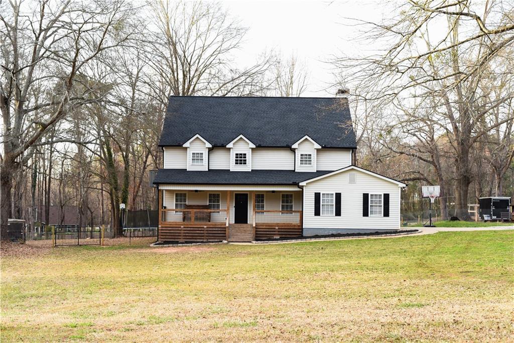 1264 GA Highway 211 Winder, GA 30680 - Photo 4 of 69 a front view of a house with swimming pool and large trees