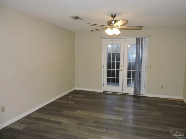 a view of an empty room with wooden floor