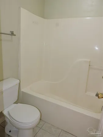 a white toilet and tub sitting next to a bathroom sink