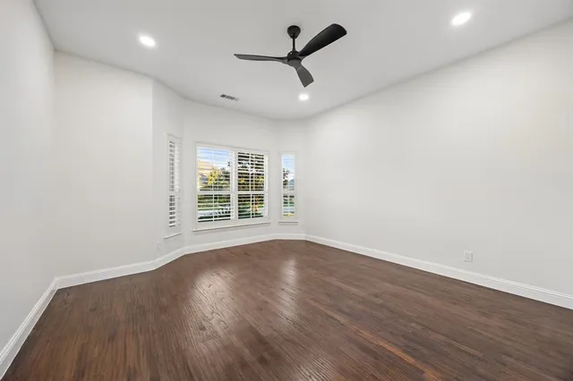 a view of a room with wooden floor and ceiling fan