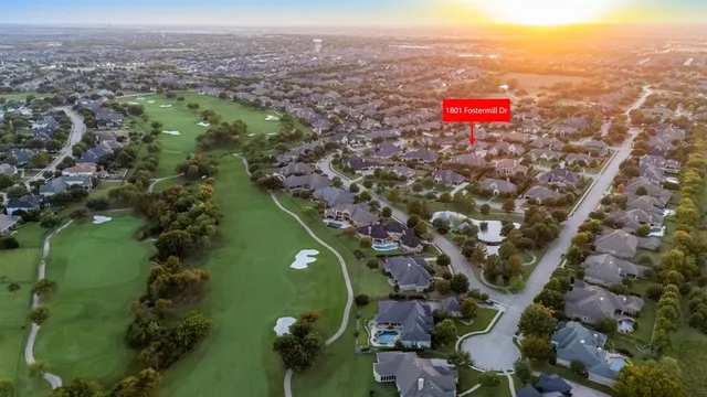 an aerial view of a houses with a lush green hillside