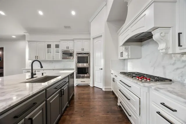 a kitchen with stainless steel appliances granite countertop a sink stove and cabinets
