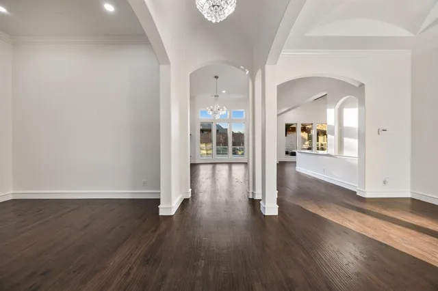 a view of a hallway with wooden floor and windows