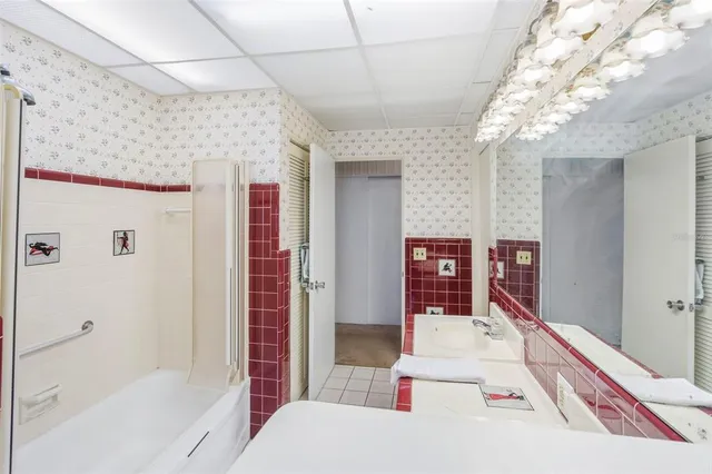 a bedroom with a bed chandelier and a window